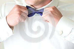 Man fastening a bow tie