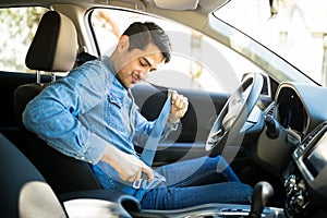Man fastening seat belt in the car