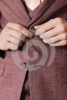 the man fastens the buttons on his jacket