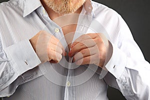 Man fastens buttons on his shirt