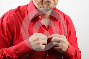 Man fastens buttons on his shirt