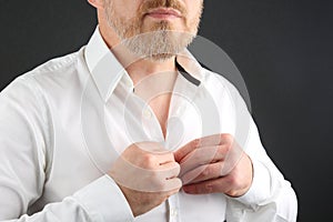 Man fastens buttons on his shirt