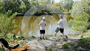 Man, father and his daughter spending good time together, going fishing, resting near river on summer day
