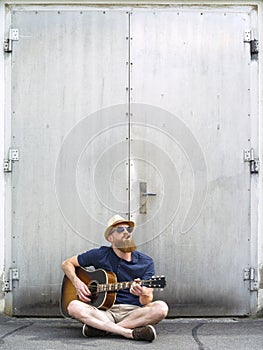 Man with fedora and cigar playing acoustic guitar