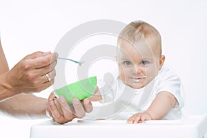 Man feeding baby with a spoon