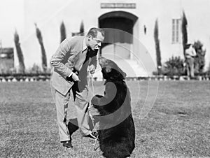 Man feeding a bear standing on his lawn