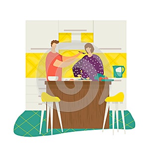 Man feeding woman spaghetti in modern kitchen, couple enjoying cooking together. Homely atmosphere, culinary and