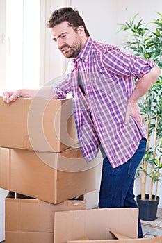 Man feeling back ache cramp moving heavy boxes