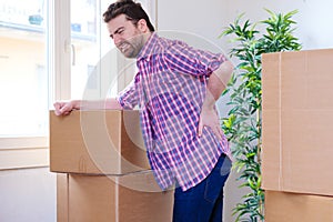 Man feeling back ache cramp moving heavy boxes