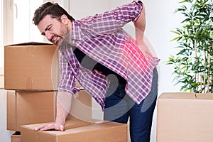 Man feeling back ache cramp moving heavy boxes