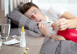 Man feeling bad lying in the bed and coughing