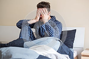 Man feeling bad and seated on the bed