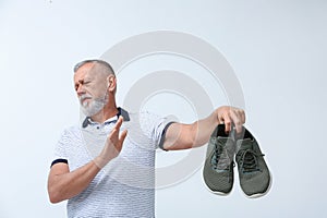 Man feeling bad smell from shoes