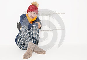 Man feeling cold in hat and pullover sitting close to radiator. Gas crisis concept