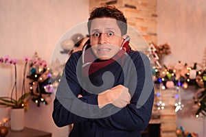 Man feeling cold inside a house at Christmas
