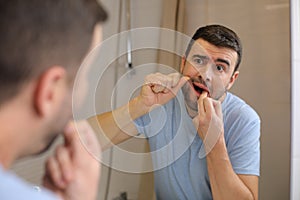 Man feeling discomfort while flossing