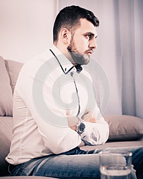 Man feeling distressed and lonely alone at home