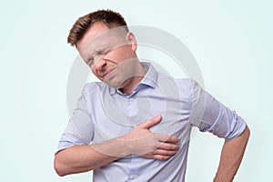 Man feeling having heart attack symptom or breast cancer