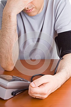 Man feeling sick and checking blood pressure