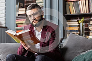 Man feeling thoughtful while reading book about astrology of money