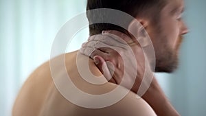 Man feels neck pain after woke up in morning, uncomfortable matrass, closeup