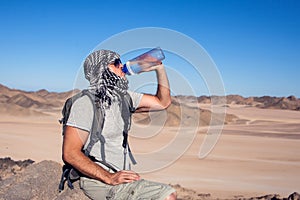 Man feels thirst and drinks water in the desert