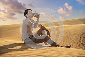 Man feels thirst and drinks water in the desert