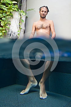 Man with feet in pool
