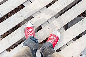 Man feet in red sneakers on cobbled road