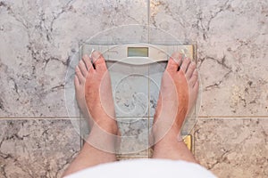 Man feet standing on weight scale