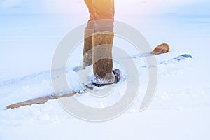 A man in felt boots on homemade skis walks through the snow into forest. Hiking, traveling, hunting, fishing.
