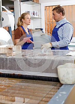 Man and female colleague cleaning glass on washing machine