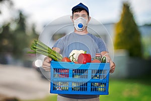 Man with FFP3 respirator face mask is delivering food and groceries during virus epidemic.