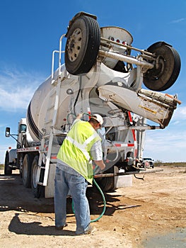 Man Fiddling With Hose on Cement Truck - Vertical