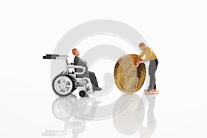 Man figurine moving euro coin towards man figurine in wheel chair