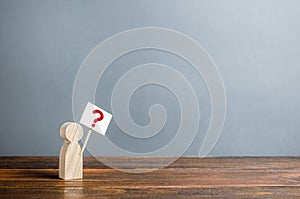 Man figurine with a poster and a question mark. Asking questions, searching for truth. Curiosity, desire to learn more and improve