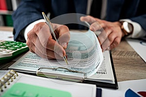 Man filling 1040 blank US tax form at the office