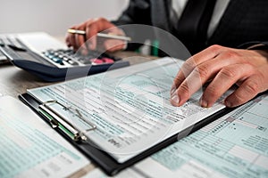 Man filling 1040 blank US tax form at the office