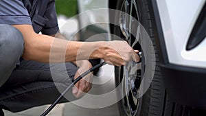 Man filling air in the tires of car inflating tire