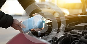 Man filling car radiator with antifreeze, closeup