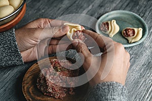 man is filling a Catalan galet with ground meat photo