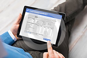 Man filling customer survey form on tablet computer