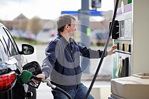 Man filling gasoline fuel in car