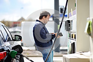 Man filling gasoline fuel in car