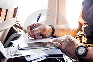 Man filling in immigration form sitting at airplane