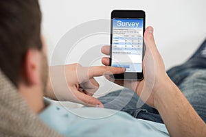 Man Filling Online Survey Form On Mobile Phone