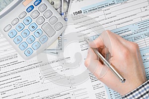 Man filling out 1040 US Tax Form - view from top - studio shot