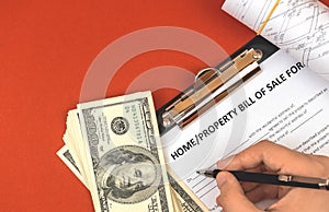 Man filling property bill of sale form. Money and real estate project documents. Office table top view photo