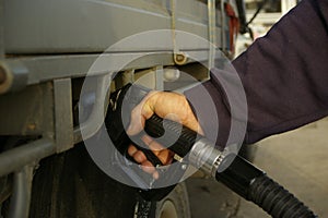 man filling up his 4WD car with fuel from a black petrol bowser, rural New South Wales