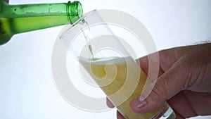 Man Fills a Glass Full of Beer from a Bottle